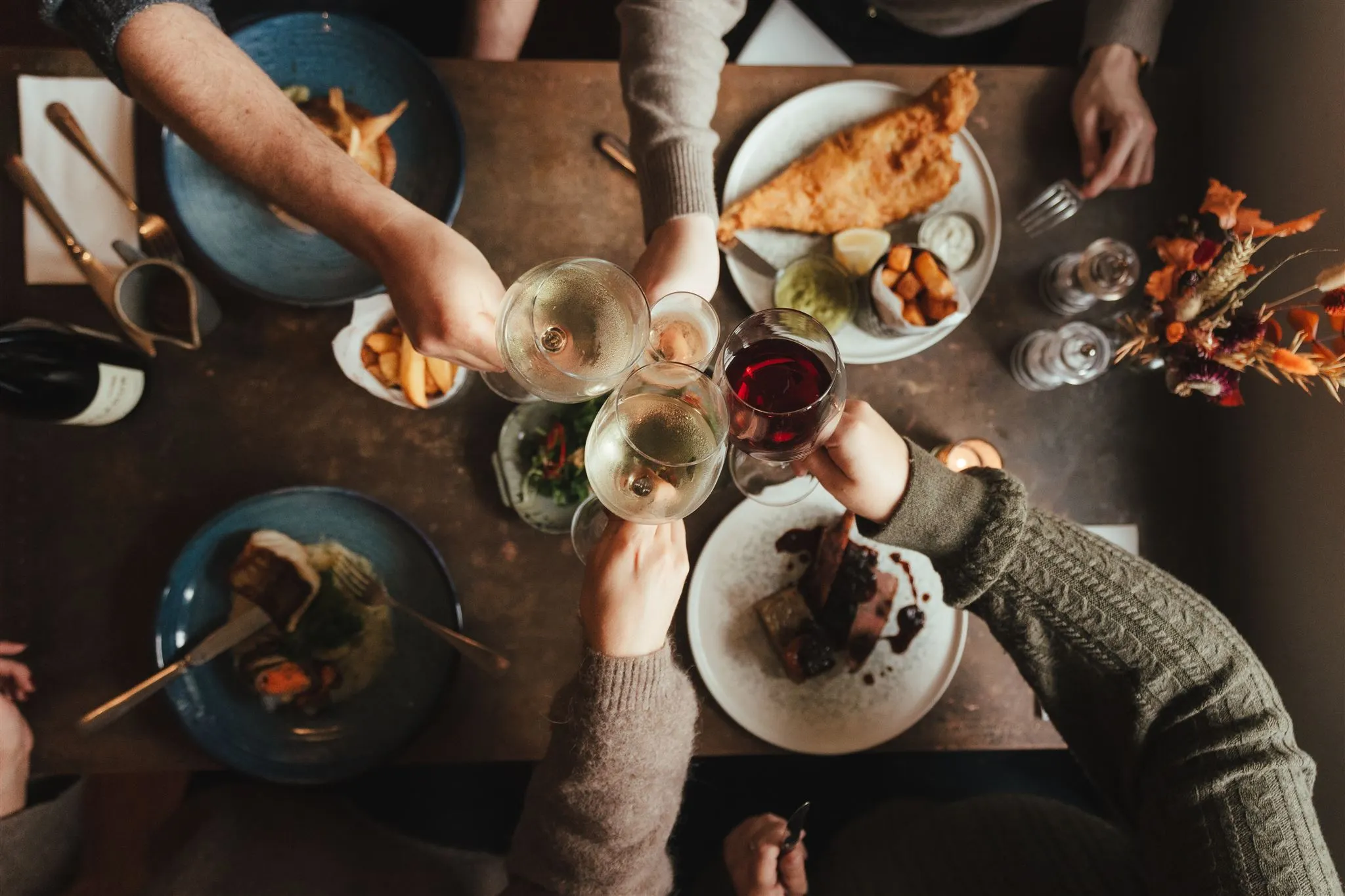 People celebrating with glasses of wines over lunch